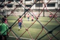 Kid training soccer football in blur background behind the net Royalty Free Stock Photo