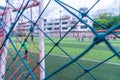 Kid training soccer football in blur background behind the net Royalty Free Stock Photo