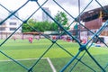 Kid training soccer football in blur background behind the net Royalty Free Stock Photo