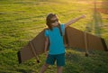 Kid traveller with backpack wings. Child playing pilot aviator and dreams outdoors in park. Dreaming, freedom and Royalty Free Stock Photo