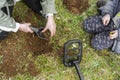 Kid treasure hunters metal detecting and digging the ground Royalty Free Stock Photo