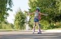 Kid tries to keep his balance and not fall, for the first time standing on roller skates. view behind. Royalty Free Stock Photo