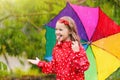 Kid with umbrella playing in summer rain Royalty Free Stock Photo