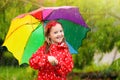 Kid with umbrella playing in summer rain Royalty Free Stock Photo
