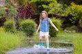 Kid with umbrella playing in summer rain Royalty Free Stock Photo