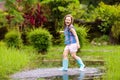 Kid with umbrella playing in summer rain Royalty Free Stock Photo