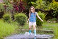 Kid with umbrella playing in summer rain Royalty Free Stock Photo