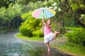 Kid with umbrella playing in summer rain. Royalty Free Stock Photo