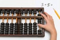 a kid using abacus to calculate simple addition equation Royalty Free Stock Photo