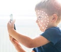 Kid using face id recognition. Boy with a smartphone gadget. Digital native children concept. Royalty Free Stock Photo