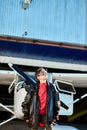 Kid waiting for private flight with father near hangar, looking thoughtfully in sky