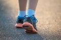 Kid walking, exercising on a rural road, close up on kids feet wearing gym shoes