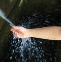 Kid washing hand in fresh, cold, potable water spring