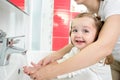 Kid washing hands with mom in bathroom Royalty Free Stock Photo