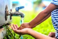 Kid washing hands with mother, selective focus point.