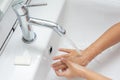 Kid washing hands in a white basin with a bar of white soap Royalty Free Stock Photo