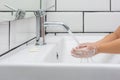 Kid washing hands in a white basin with a bar of white soap Royalty Free Stock Photo