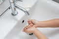 Kid washing hands in a white basin with a bar of white soap. Royalty Free Stock Photo