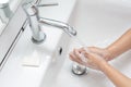 Kid washing hands in a white basin with a bar of white soap Royalty Free Stock Photo