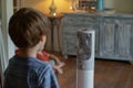 kid watching an oscillating tower fan moving side to side