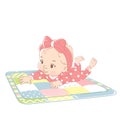 Cute little baby girl laying on stomach, on playing mat.