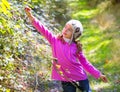 Kid winter girl picking mulberry berries in the forest