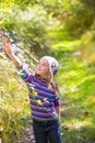 Kid winter girl picking mulberry berries in the forest