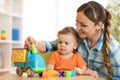 Kid and woman playing with developmental toy in daycare or kindergarten