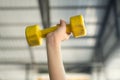 Kid working out with dumbbells in the sports hall of the club. Child hand holding yellow dumbbell on green background Royalty Free Stock Photo