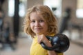 Kid workout kid in gym. Kid raising a kettlebell. Cute child training with dumbbells. Kids fitness. Kid boy exercising Royalty Free Stock Photo