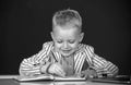 Kid writing in class. Portrait of funny pupil of primary school study in classroom at school.