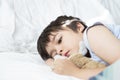 Kid 6-7 year old  lying on bed, Sleepy child waking up the morning in his bed room with morning light, Cute little boy sleeping Royalty Free Stock Photo