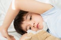 Kid 7 year old lying on bed, Sleepy child waking up the morning in his bed room with morning light, little boy sleeping with his Royalty Free Stock Photo