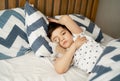 Kid 7 year old lying on bed, Sleepy child waking up the morning in his bed room with morning light, little boy sleeping with his Royalty Free Stock Photo