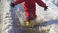 Kid in rainboots jumping in the ice puddle