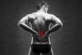 Kidney pain. Man with backache. Handsome muscular bodybuilder posing on gray background Royalty Free Stock Photo