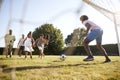 Kids approach dad in goal during family football game Royalty Free Stock Photo