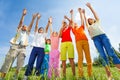 Kids with arms up stand straight in row