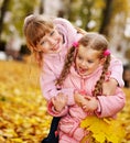 Kids in autumn orange leaves.