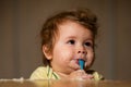 Kids baby eating with dirty face. Cheerful smiling child child eats itself with a spoon Baby eating with dirty face Royalty Free Stock Photo