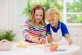 Kids baking. Children cooking in white kitchen