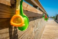 Kids beach toys hanging on boardwalk entrance to the beach Royalty Free Stock Photo