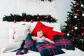 Kids on bed in bedroom near Christmas tree. Happy New Year and Merry Christmas. Christmas decorated interior. The concept of Royalty Free Stock Photo