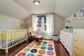 Kids bedroom with nice crib and colorful rug Royalty Free Stock Photo