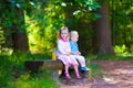 Kids on a bench in a summer forest Royalty Free Stock Photo