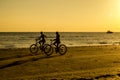 Kids on bicycles silhouette at the beach. Royalty Free Stock Photo