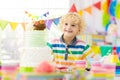 Kids birthday party. Child blowing out cake candle Royalty Free Stock Photo