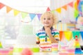 Kids birthday party. Child blowing out cake candle Royalty Free Stock Photo