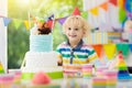 Kids birthday party. Child blowing out cake candle Royalty Free Stock Photo