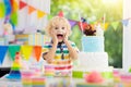 Kids birthday party. Child blowing out cake candle Royalty Free Stock Photo